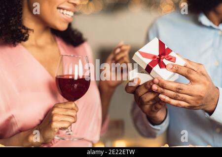 Young black man giving box with jewelry to his girlfriend Stock Photo