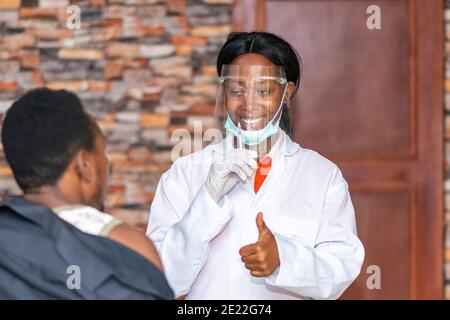 female african doctor gives a patient a thumbs up after administering an injection Stock Photo
