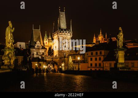 Night view of the illuminated St Nicolas church,Charles Bridge and Prague Castle,Czech republic.Night city scene.Long exposure city lights people in m Stock Photo
