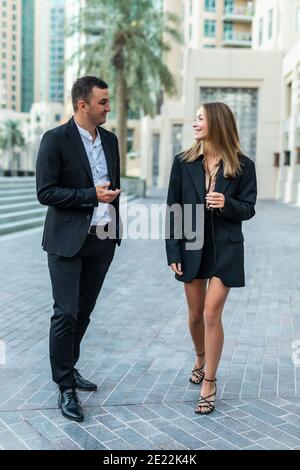 Businessman And Businesswoman Walking Along Street Stock Photo