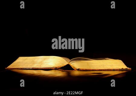 One open book on reflective black surface Stock Photo