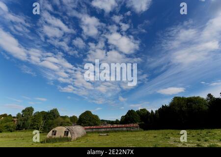 Big blue sky and white clouds over farm buildings and countryside in Wiltshire. Stock Photo