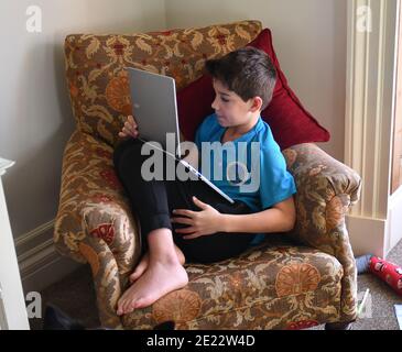Boy school pupil working at home on laptop computer during the pandemic lockdown Stock Photo