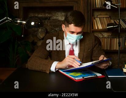 Businessman in face protective mask work late. New normality. Stock Photo