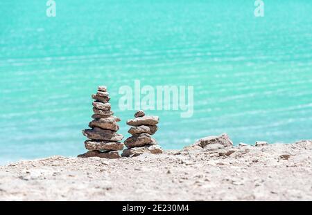 Wish pyramids in front of the Laguna Verde (Green Lagoon), Uyuni, Bolivia. Stock Photo