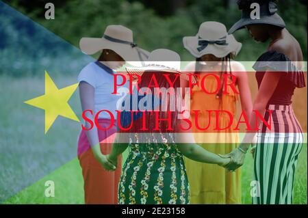 Pray for South Sudan. Group of four african women holding hands and praying. Concept of crisis in Africa country. Stock Photo