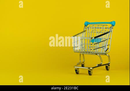 Empty shopping cart isolated on yellow background with empty space for text Stock Photo