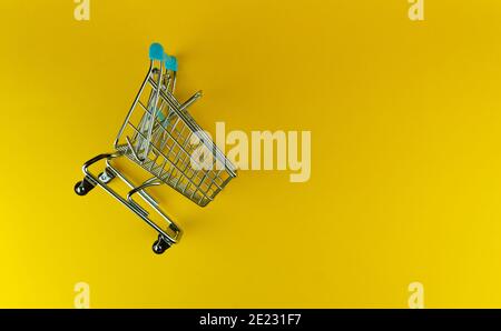 Overhead shot of empty shopping cart. isolated in yellow background, copy space. Stock Photo