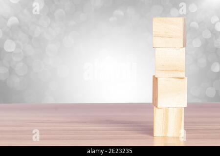 Wooden blocks stack on the table with a bokeh background. Abstract geometric real floating wooden cube. Stock Photo