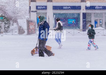 People walking down a snowy street impossible for car traffic. Filomena heavy snowfall. Madrid, Spain Stock Photo