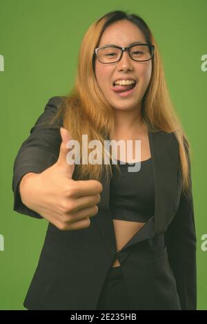 Young Asian businesswoman against green background Stock Photo