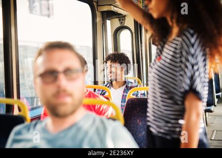 Charming Afro-American man is looking through the bus window and smiling. Stock Photo