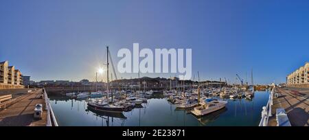 Panoramic image of St Helier Marina early morning from the West marina wall with the visitor births on the left hand side. Stock Photo