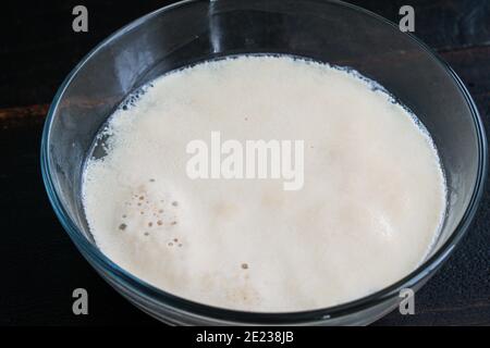 Proofing Active Dry Yeast: Yeast and sugar foaming up in warm water Stock Photo