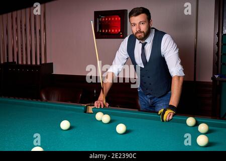 male standing next to billiards table, looking at camera, posing, in formal wear. portrait Stock Photo