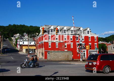 People on motorbike passing railroad crossing in front of discount liquor store, Cumberland, Maryland MD, USA Stock Photo