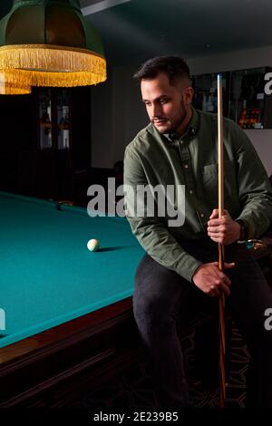 guy sits depressed after bad billiards game, loser had unsuccessful snooker game. portrait Stock Photo