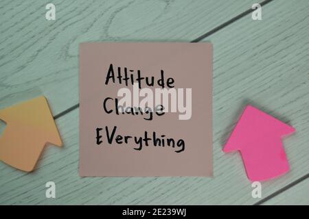 Attitude Change Everything write on sticky notes isolated on Wooden Table. Stock Photo