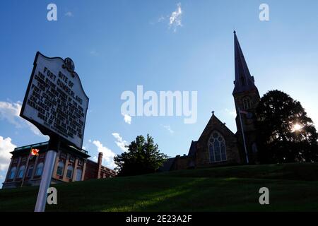 Sign marking site of Fort Cumberland store houses, Masonic Temple building and Emmanuel Parish church in background, Cumberland, Maryland MD, USA Stock Photo