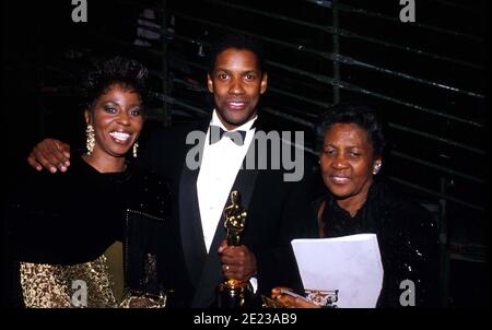 Denzel Washington With Wife Paulette Washington And Mother Lennis Washington at the 62nd Academy Awards ceremony March 26, 1990 in Los Angeles, CA. Washington received an Oscar for Best Actor in a Supporting Role for his performance as Trip in 'Glory.'  Credit: Ralph Dominguez/MediaPunch Stock Photo