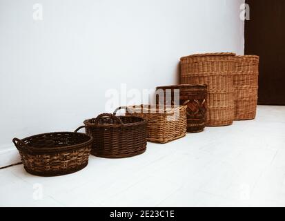 Row of handmade natural wicker baskets with handle and cap, beautiful home storage containers concept Stock Photo