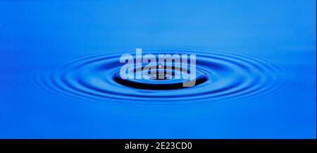 Circular waves on the surface of the blue water Stock Photo