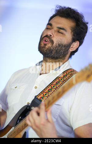 Hispanic emotional male musician singing passionately and playing on electric guitar in a studio Stock Photo