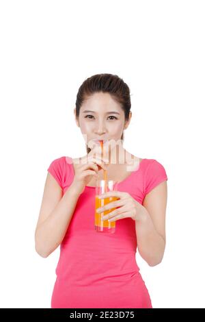 Young woman in pink dress drinking a glass of orange juice high quality photo Stock Photo