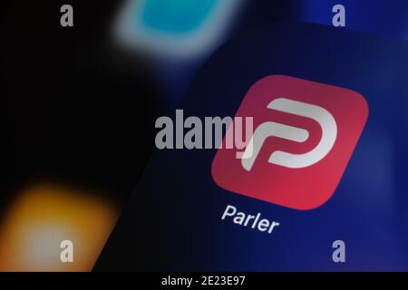 Parler app logo seen on the screen of iPad. Parler is a social media platform banned in the US. Stock Photo