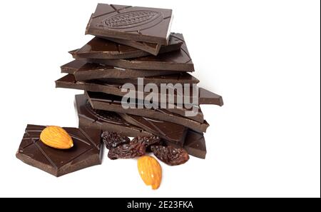 Closeup pieces of dark, inferior chocolate, almonds and raisins on a white background Stock Photo