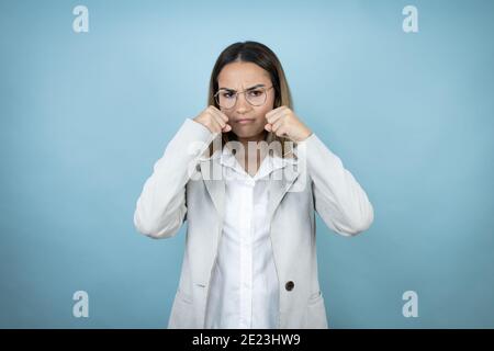 Young business woman over isolated blue background depressed and worry for distress, crying angry and afraid. Sad expression. Stock Photo