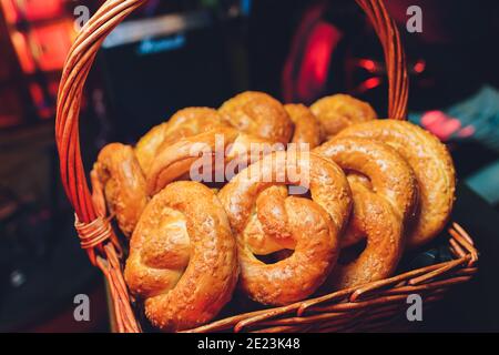Fresh handmade original Bavarian pretzels from the domestic master baker on a green checkered tea towel many blurry pretzels in the background Stock Photo