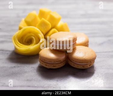 Mango Macarons with Mango Rose on White Marble Stock Photo