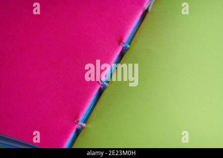 Closeup shot of open notebook details with blank pink and green sheets Stock Photo