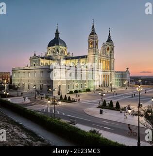 Asphalt square illuminated with street lamps near old palace against sundown sky in Madrid, Spain Stock Photo