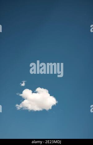 From below of white fluffy cumulus cloud floating in clear blue sky on sunny day Stock Photo