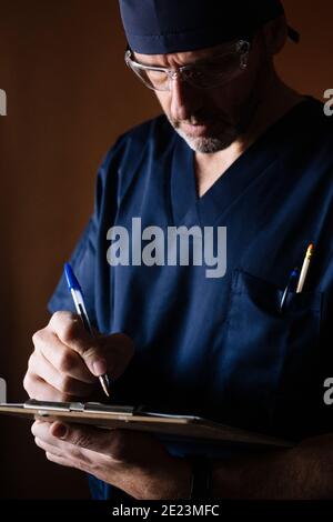 Portrait of a middle aged male doctor writing a report Stock Photo