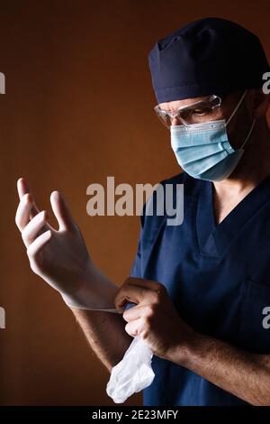 Doctor surgeon putting on latex gloves Stock Photo