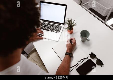 Young businessman using laptop at desk in coworking Stock Photo
