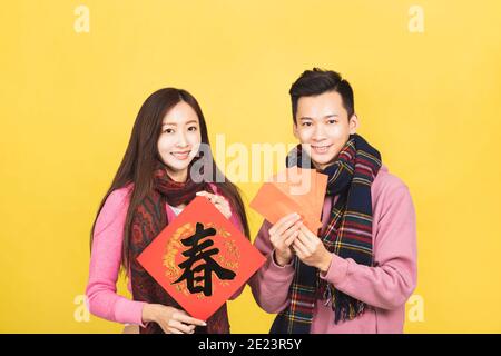 happy asian young couple celebrating for chinese new year. chinese text: spring Stock Photo