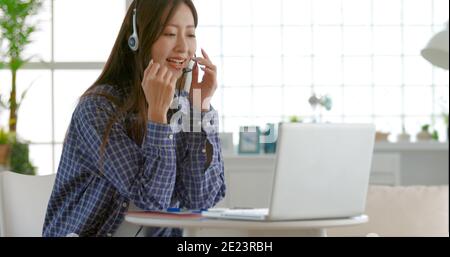 young woman  wear headset and using video conference  on laptop computer at home