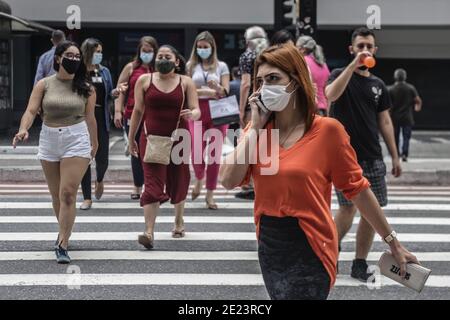 Sao Paulo, Brazil. 11th Jan, 2021. Pedestrians wearing face masks cross a street in Sao Paulo, Brazil, Jan. 11, 2021. Credit: Rahel Patrasso/Xinhua/Alamy Live News Stock Photo