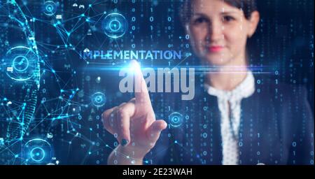 Business, Technology, Internet and network concept. Young businessman working on a virtual screen of the future and sees the inscription: Implementati Stock Photo