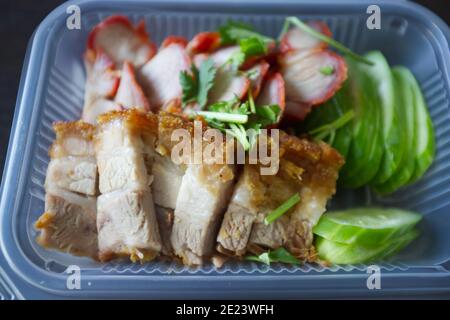 Barbecued red pork in sauce and crispy pork with rice in package . Stock Photo