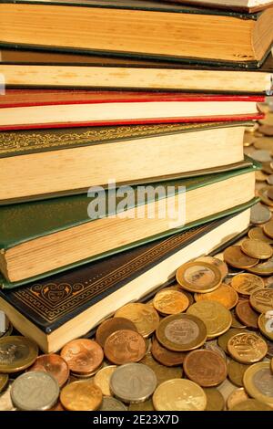 Pile of classics books surrounded with coins. The currency of the money is Brazilian Real Stock Photo