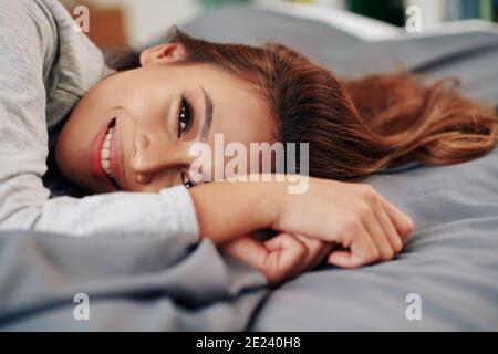 Lazy Asian woman lying on bed Stock Photo