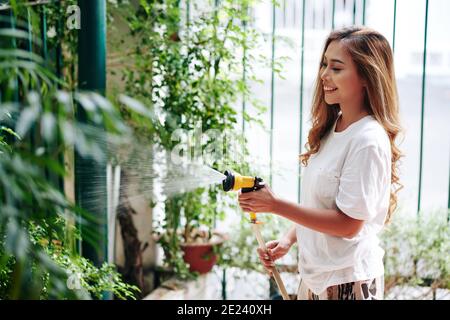 Woman watering plants in backyard Stock Photo