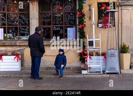 WARSAW, POLAND - Dec 27, 2020: Man and child standing in front of a closed restaurant Stock Photo