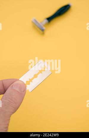 Holding Razorblade Razor blade against yellow background, symbol image, top view Stock ...