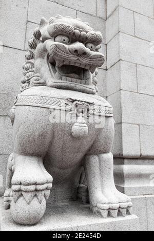 Traditional white Chinese lion statue at the entrance to Buddhist temple in Hong Kong city Stock Photo